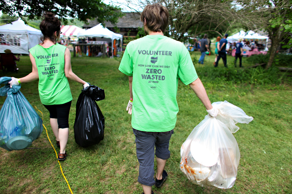 Volunteers carry recycling, compost, and trash bags back to the Zero Waste Event Productions tent in 2013.