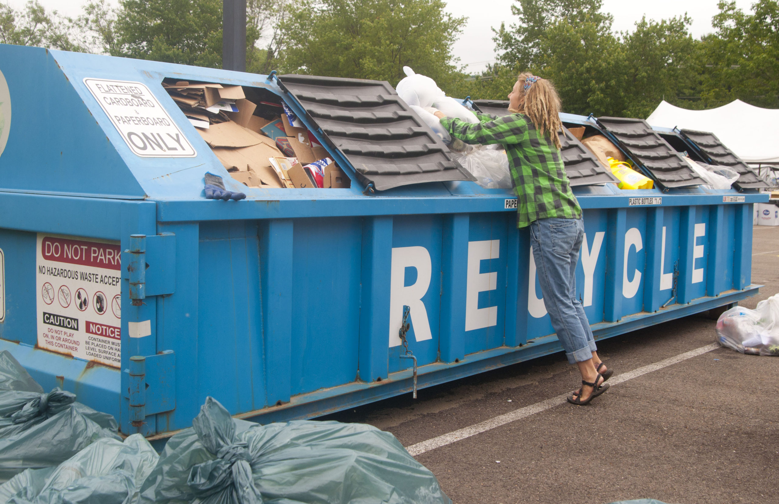 A volunteers adds recycling to a roll off at Nelsonville Music Festival.