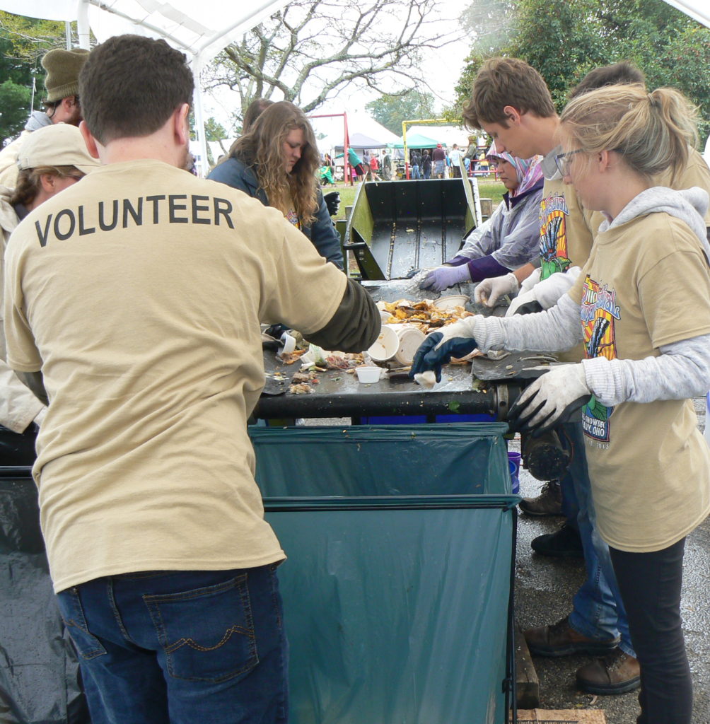 Volunteer sort recycling and compost on a mobile conveyor belt at the Ohio Pawpaw Festival in 2016.