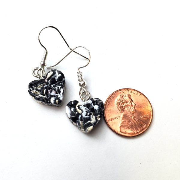 Thick plastic heart-shaped earring next to a penny to show size. Earrings are slightly smaller.