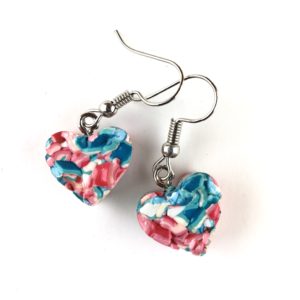 Thick plastic heart-shaped earring. Light pink, light and dark blue and white speckling. Ripple texture top. Silver hooks.